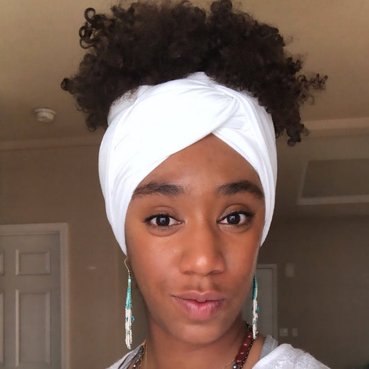 black woman wearing stretchy white headwrap with curly hair