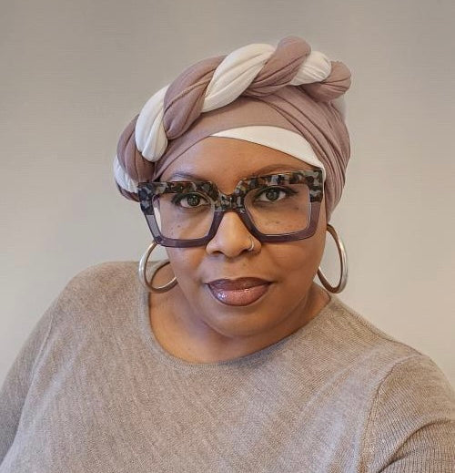 black woman wearing a double headwrap style that includes the colors white and beige