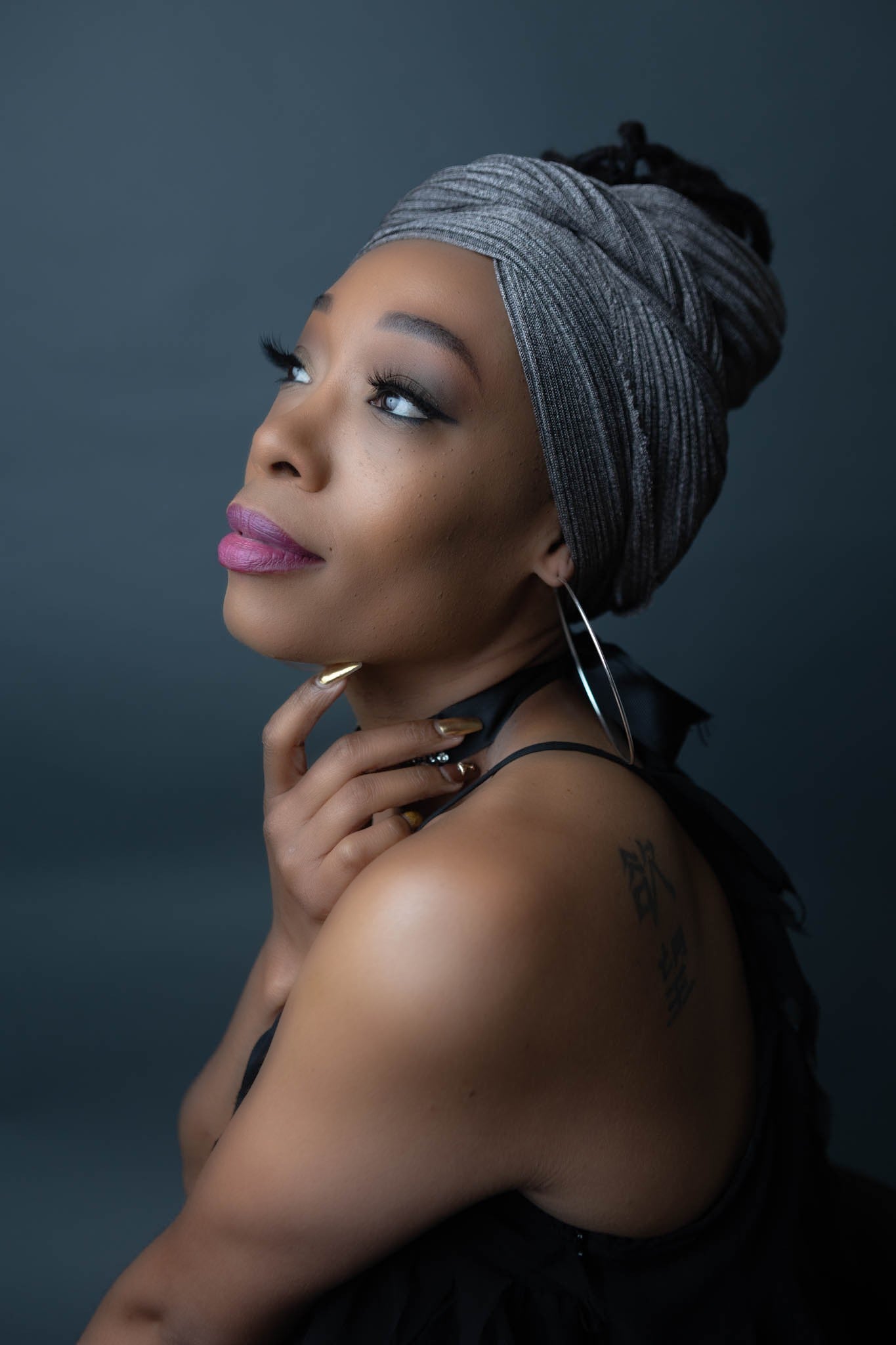 black model wearing stretch ribbed shimmery silver head wrap