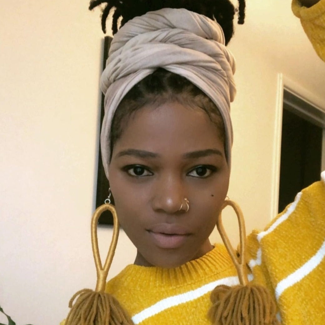  black model with locs in updo style with soft, textured, stretchy, light shade of brown faux suede head wrap. 